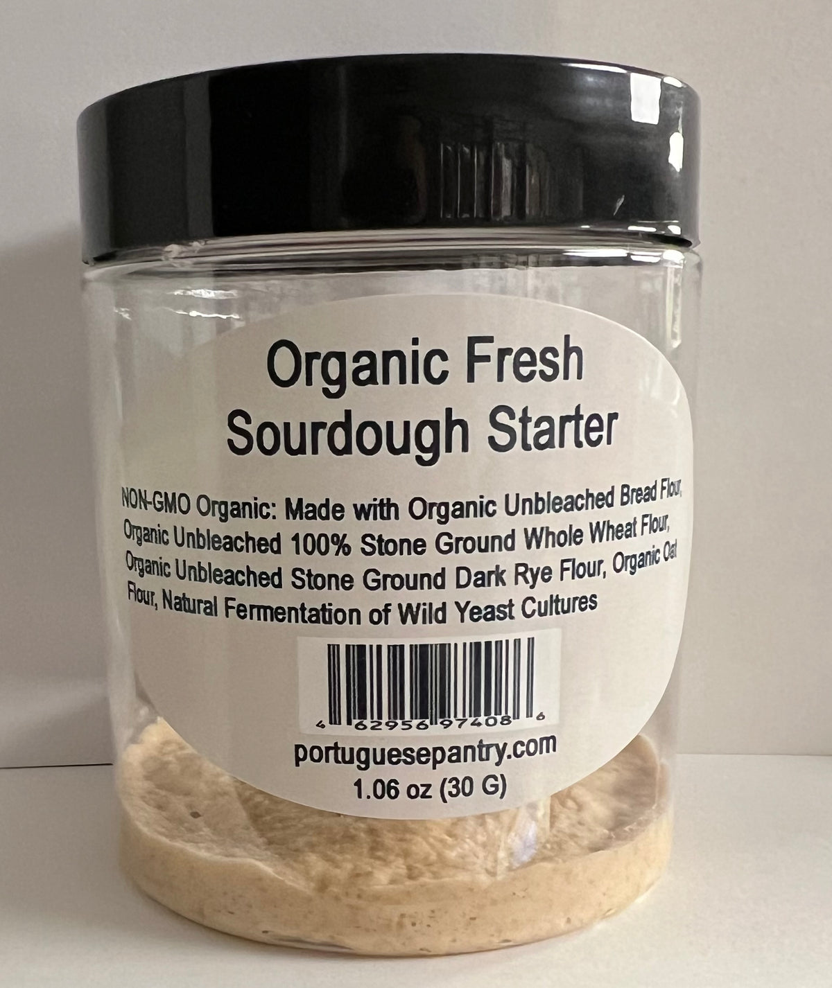 A clear plastic jar of Portuguese Pantry Organic Fresh Sourdough Starter with a black lid and a white label, containing a beige powder.